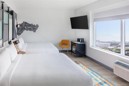 a hotel room with two beds and a window at Aloft Fort Lauderdale Airport & Cruise Port in Fort Lauderdale