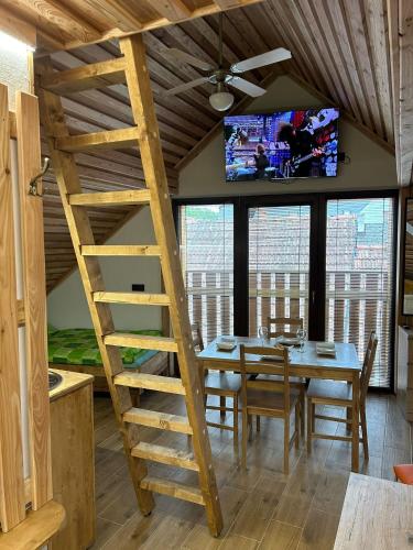 a dining room with a wooden ladder and a tv at Penzion s rafty in Vyšší Brod
