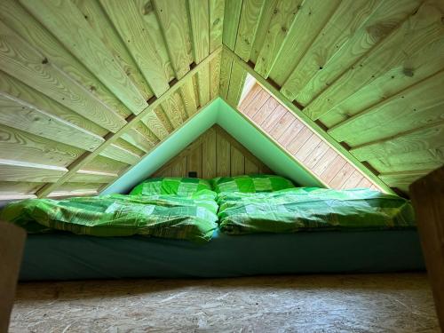 a bed in a room with a wooden ceiling at Penzion s rafty in Vyšší Brod