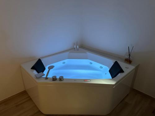 une baignoire jacuzzi avec une lumière bleue dans la chambre dans l'établissement Maison Costa Masciarelli, à LʼAquila