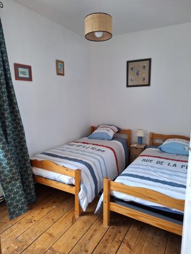 Cette chambre comprend 2 lits jumeaux et du parquet. dans l'établissement Maison en pierre proche mer, commerces et bus, à Pordic