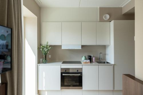 a kitchen with white cabinets and a sink at Numa Copenhagen Nørrebro in Copenhagen