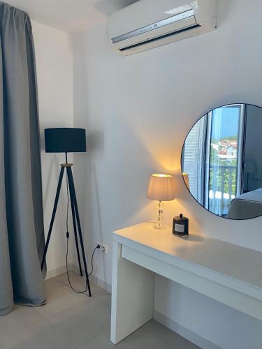 a room with a mirror and a table with a lamp at Appartement Tara in Malinska