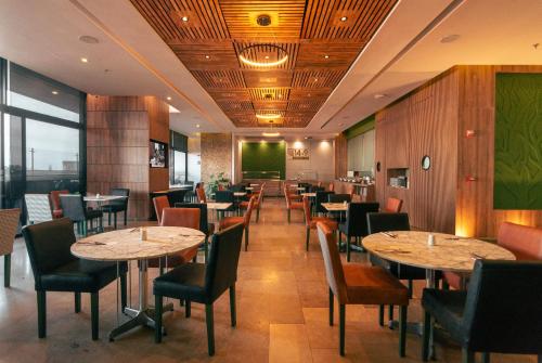 a dining room with tables and chairs in a restaurant at Hotel Mocawa Plaza Armenia in Armenia