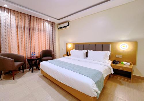 a hotel room with a large bed and a desk at FASHION INTERNATIONAL HOTEL in Dar es Salaam