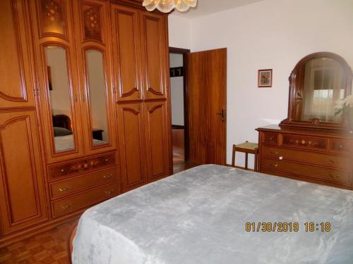 a bedroom with a large wooden cabinet and a bed at 5 Palme in Terzo dʼ Aquiléia