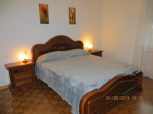 Terzo dʼ Aquiléiaにある5 Palmeのベッドルーム1室(大型ベッド1台、ナイトスタンド2台付)