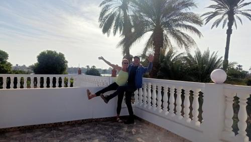 a man and a woman standing on a white fence at Dream Garden Luxor in Luxor