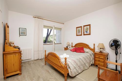 パラモスにあるLa Fosca Breezeのベッドルーム1室(木製ベッド1台、窓付)