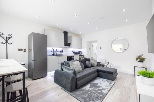 a living room with a couch and a kitchen at WestPoint Luxury Apartment in Manchester