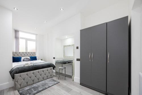 a bedroom with a bed and a large cabinet at WestPoint Luxury Apartment in Manchester