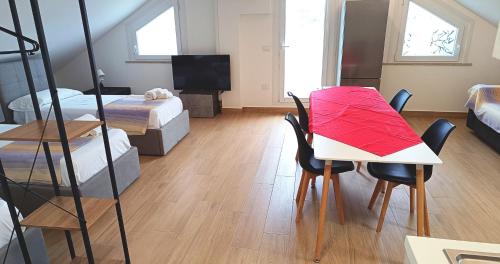 a room with two beds and a table with chairs at Residenza delle Nazioni in Gatteo a Mare