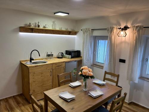 a kitchen with a table and a sink and a table and chairs at Penzion s rafty in Vyšší Brod