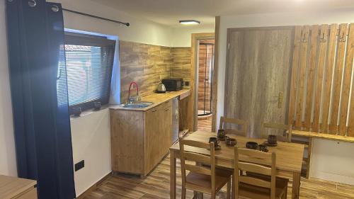 a kitchen with a table and chairs and a kitchen with a counter at Penzion s rafty in Vyšší Brod