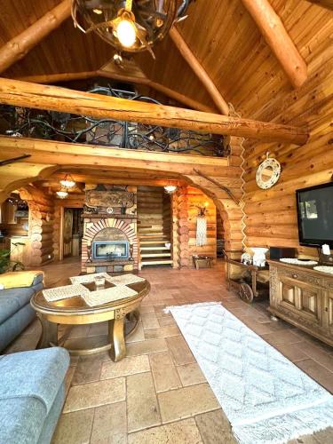 a living room with a couch and a tv in a cabin at Cedrowa Villa - Rezydencja nad jeziorem in Ełk
