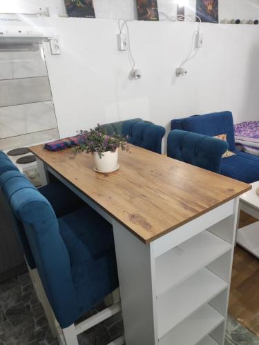 a table with blue chairs in a room at Prenoćište Inđija Hrvić in Inđija