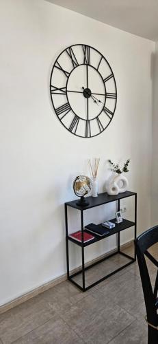 a clock on a wall above a shelf with a clock at Casa Amina in Calpe