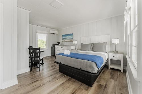 a bedroom with a bed and a desk and a chair at Mia's Boutique Hotel in Nags Head