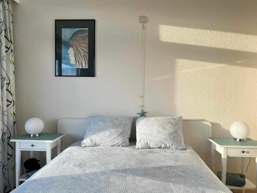 een slaapkamer met een bed met 2 tafels en een foto bij Appartement Residentie Astrid met private parking in Bredene