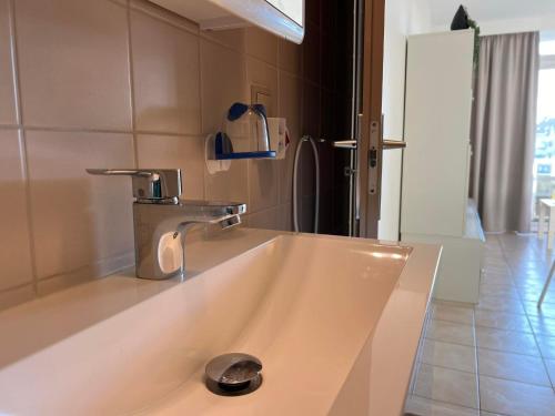 lavabo con grifo en el baño en Appartement Residentie Astrid met private parking, en Bredene