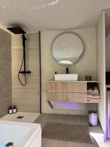 une salle de bain avec un lavabo et un miroir dans l'établissement SPA PRIVATIF - LOVE ROOM LUXE - PROCHE DISNEY, à Marles-en-Brie