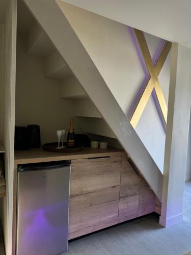 une cuisine mansardée avec un comptoir en bois et une fenêtre dans l'établissement SPA PRIVATIF - LOVE ROOM LUXE - PROCHE DISNEY, à Marles-en-Brie