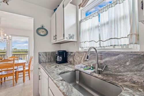 a kitchen with a sink and a dining room at Lucky Enough in Gulf Shores