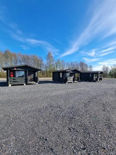 two buildings in a parking lot with gravel at Kirjurin Leirintä in Pori