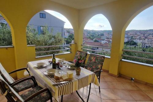 a dining room with a table and chairs and windows at Sunce 1 in Vrbnik
