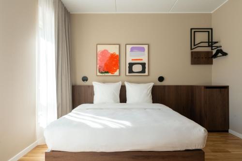 a bedroom with a large bed with white sheets at Numa Copenhagen Nørrebro in Copenhagen