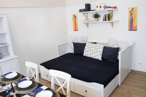 um pequeno quarto com uma cama e 2 cadeiras em Casa Donnalby em Monopoli