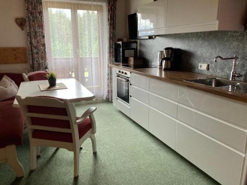 a kitchen with a table and a sink and a stove at Ellmauhof in Pfarrwerfen