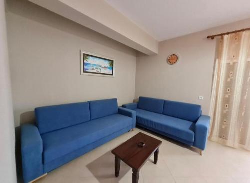 a living room with a blue couch and a table at Apartments Vila Emiliano in Borsh