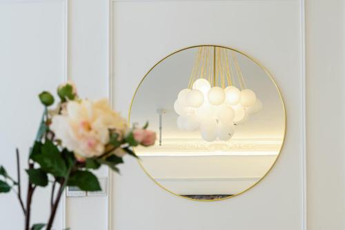 a mirror on a wall with a vase of flowers at Shanghai Yi Du B&B - Yu Garden Bund Store, 400m near Yu Garden subway in Shanghai
