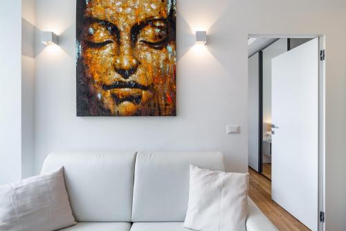 ein Bild eines Gesichts an einer Wand über einer weißen Couch in der Unterkunft Moscova Luxury Home in Mailand