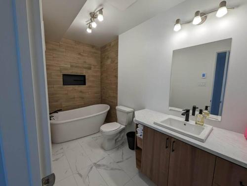 a bathroom with a tub and a toilet and a sink at La Vue - Mountain Top Cottage in Notre-Dame-de-la-Salette