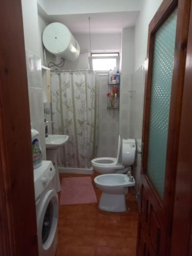 a bathroom with a toilet and a sink and a shower at Goni Guest House in Sarandë