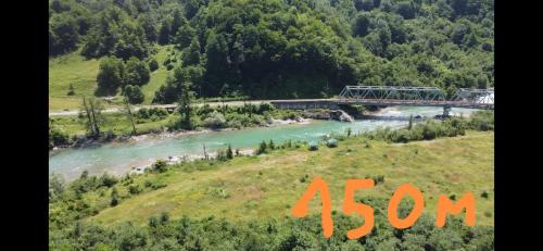 a view of a river with a bridge in the background at Pine corner Mojkovac in Mojkovac
