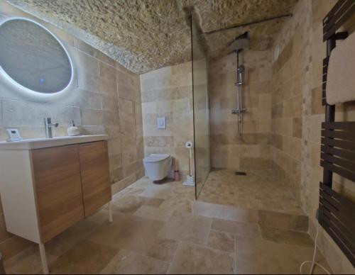 La salle de bains est pourvue d'une douche et d'un lavabo. dans l'établissement Le Cocon Troglodyte, à Saint-Étienne-de-Chigny