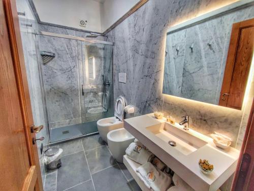 a bathroom with a sink and a toilet and a shower at Palazzo Iaquinta - Rooms, Restaurant & Wellness in Cicerale