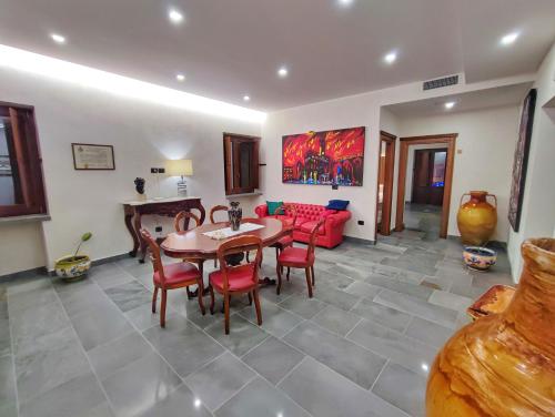 uma sala de estar com uma mesa e um sofá vermelho em Palazzo Iaquinta - Luxury Rooms & Wellness em Cicerale