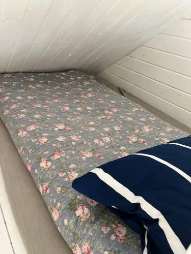 a bed in a small room with flowers on it at Kevade talu puhkemaja in Rämsi