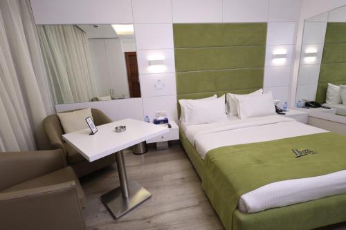 a room with two beds and a table and a mirror at Ibiza Hotel in Jounieh
