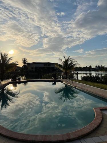 a large swimming pool with a reflection of the sky at Beautiful 3 Bed 3 & a half Bath Home with Pool & Dock Slip in Freeport
