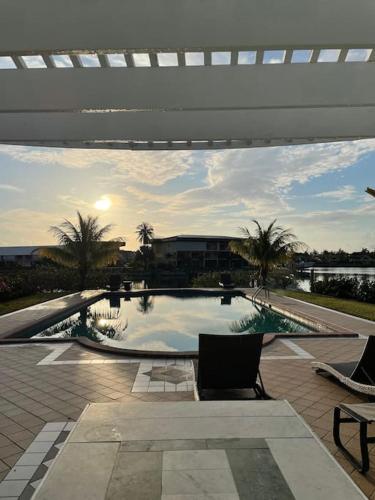 a swimming pool with two chairs and a table at Beautiful 3 Bed 3 & a half Bath Home with Pool & Dock Slip in Freeport