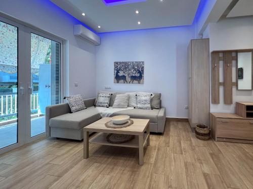 a living room with a couch and a table at Raise Varkiza Serenity Suite in Vari