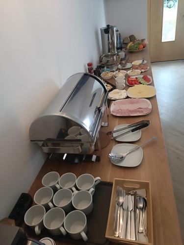 a long table with plates and utensils on it at Pokoje u Daniela in Miedzygorze