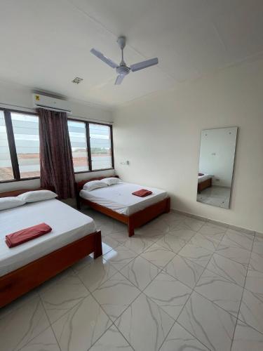 um quarto com 2 camas e um espelho em Big & confortable apartment for 6 - Center of Osu La Crescent em Accra