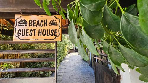 un cartel para una casa de huéspedes en un jardín en Beach Guest House - GMT en Río de Janeiro
