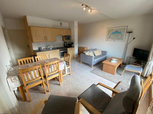 une cuisine et un salon avec une table et des chaises dans l'établissement Appartement lumineux et spacieux au centre de Châtel, proche télécabine et Multi Pass inclus! - FR-1-693-9, à Châtel